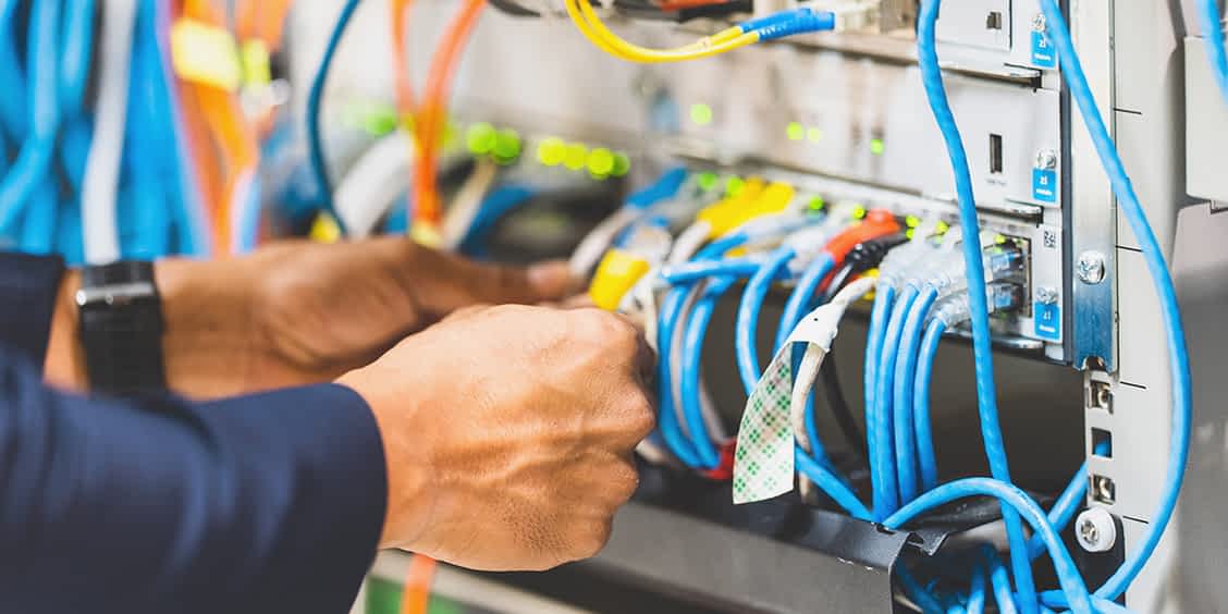 IT technician managing Ethernet cables and network hardware for WiFi optimization at Express PC Pro