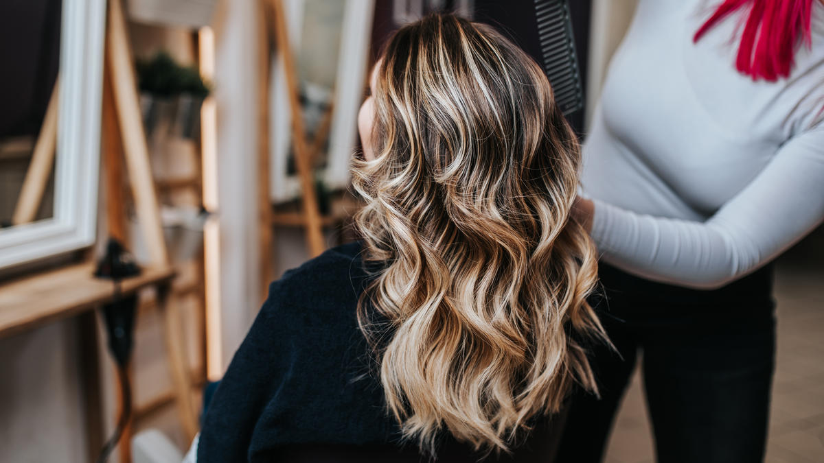 Client with freshly styled wavy blonde hair being attended to at a Japanese Hair Salon in NYC.
